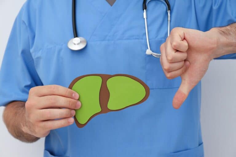 Paper liver issues in the doctor's hand on light background