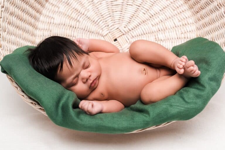 newborn sleeping on a green pillow